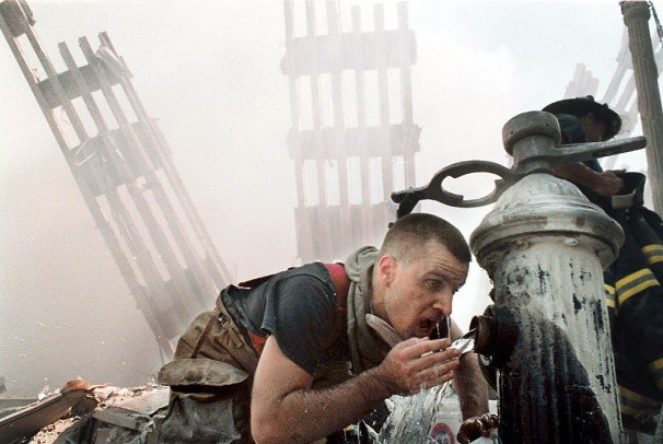 Customs Volunteer Firefighter Michael Saber drinks water from a fire hydrant in the rubble of the World Trade Center towers.