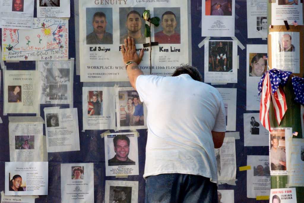 A man braces himself for support against a wall showing photos of missing people outside Bellevue Hospital in New York City on September 16.