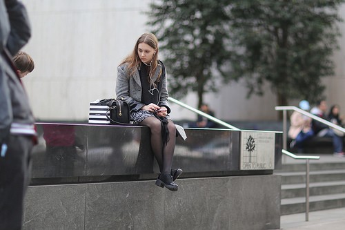 A woman on a plaza along 6th Avenue at 43rd Street.