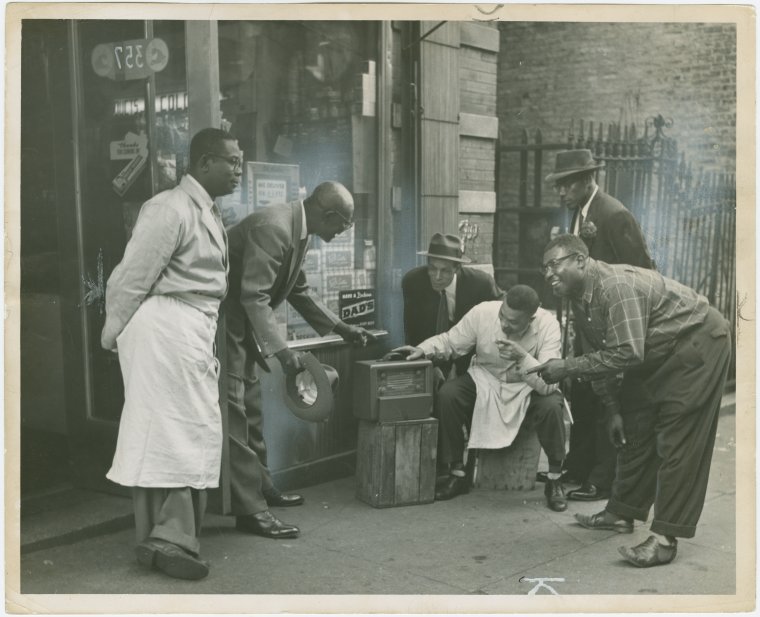 Old days in Harlem: Harlem residents in front of shop listening to the radio